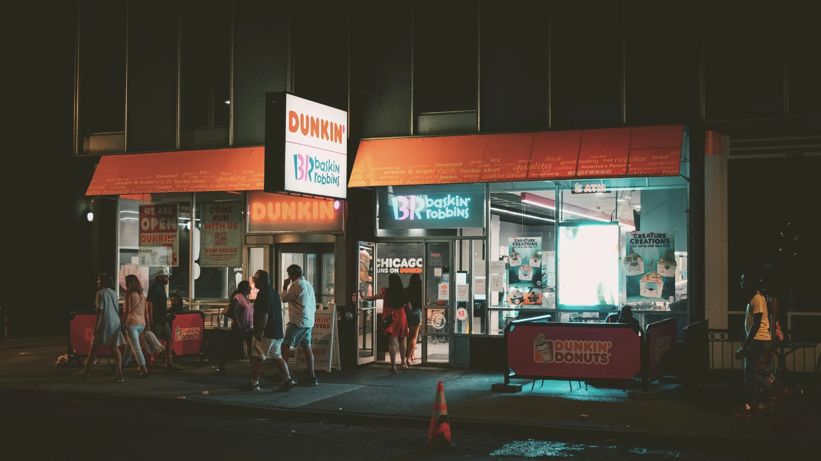 夜幕下的Dunkin’与Baskin-Robbins联合门店，顾客排队购买美食。