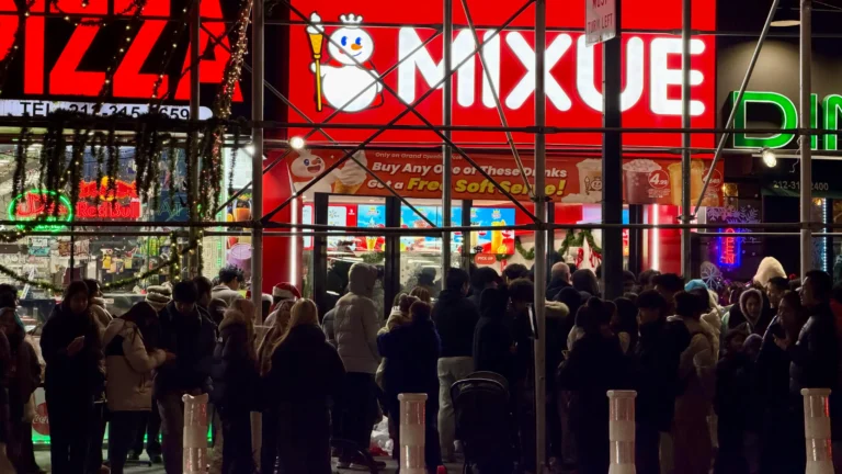 纽约曼哈顿中城蜜雪冰城门店夜间排队人群，店招与促销横幅清晰可见