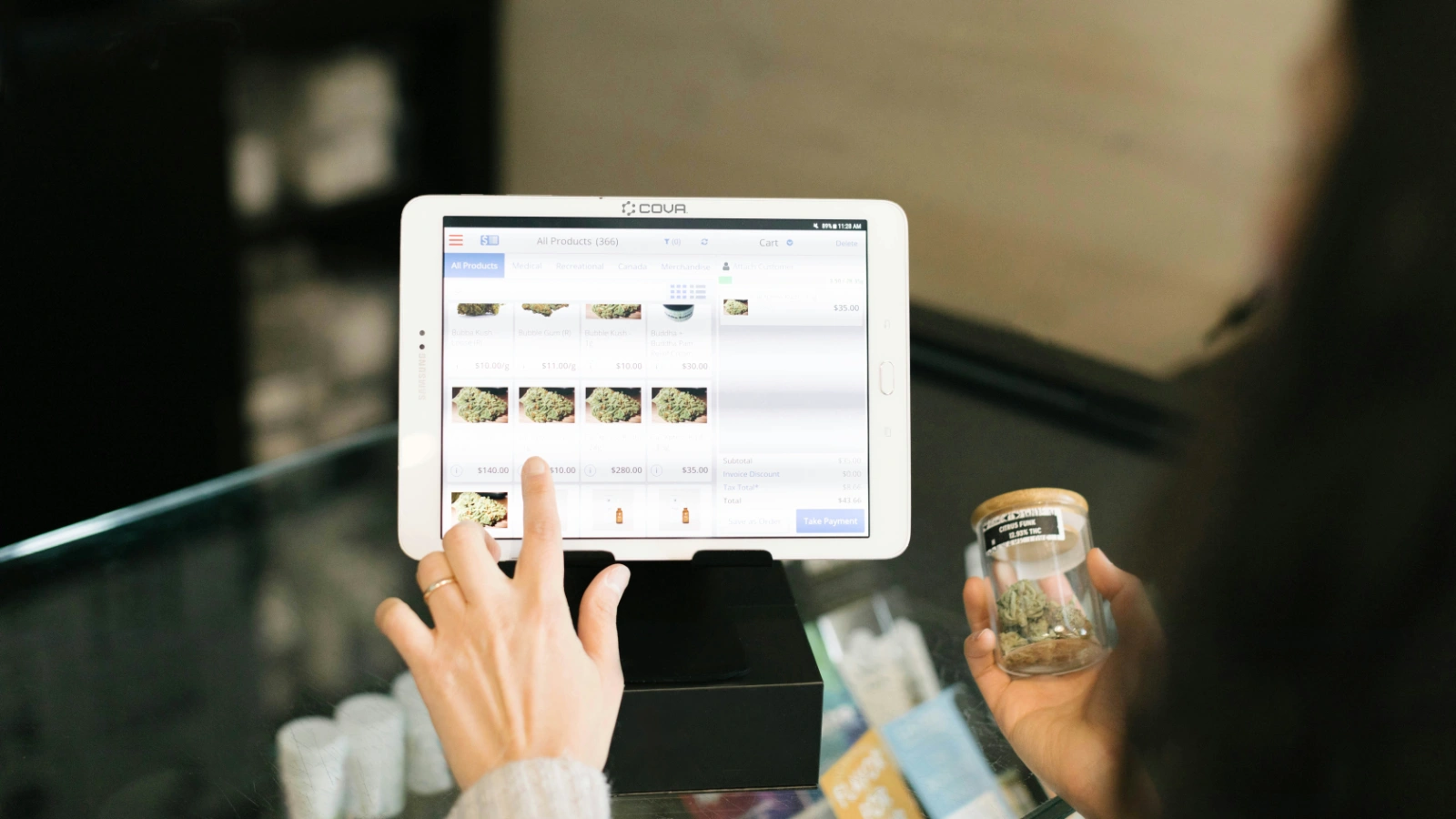 顾客在柜台前操作平板式POS系统,屏幕显示商品与结账界面,体现数字化点单与收银流程。