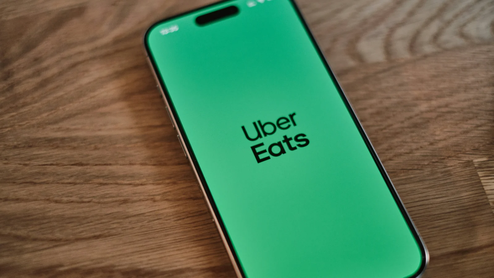 手机屏幕显示Uber Eats应用标识,配图用于说明Uber Eats平台佣金、费率调整和外卖平台成本变化