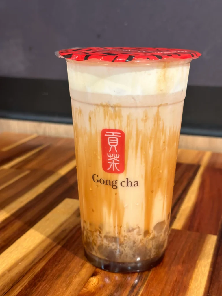 美国贡茶门店饮品实拍,黑糖珍珠奶茶装在透明杯中,展示贡茶经典奶茶产品与品牌标识