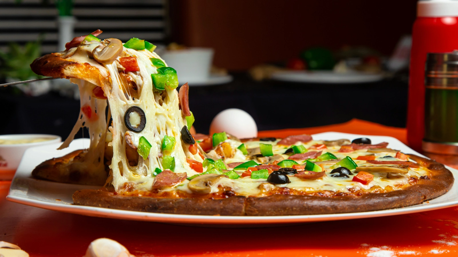 一块拉丝披萨被从整张披萨中拿起,展示披萨点餐和家庭聚餐场景,呼应餐饮AI在披萨推荐、套餐搭配和智能点餐中的应用。