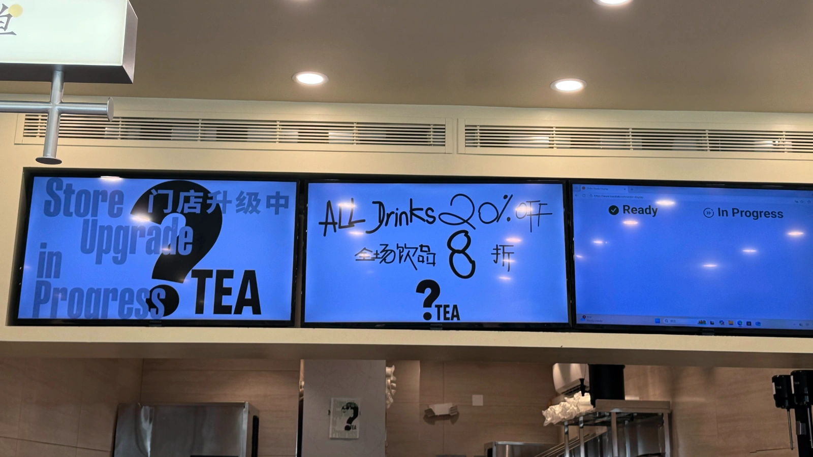 纽约 ?Tea 门店内电子屏显示“门店升级中”和“All Drinks 20% Off”信息,旁边仍可见门店取餐状态屏幕。