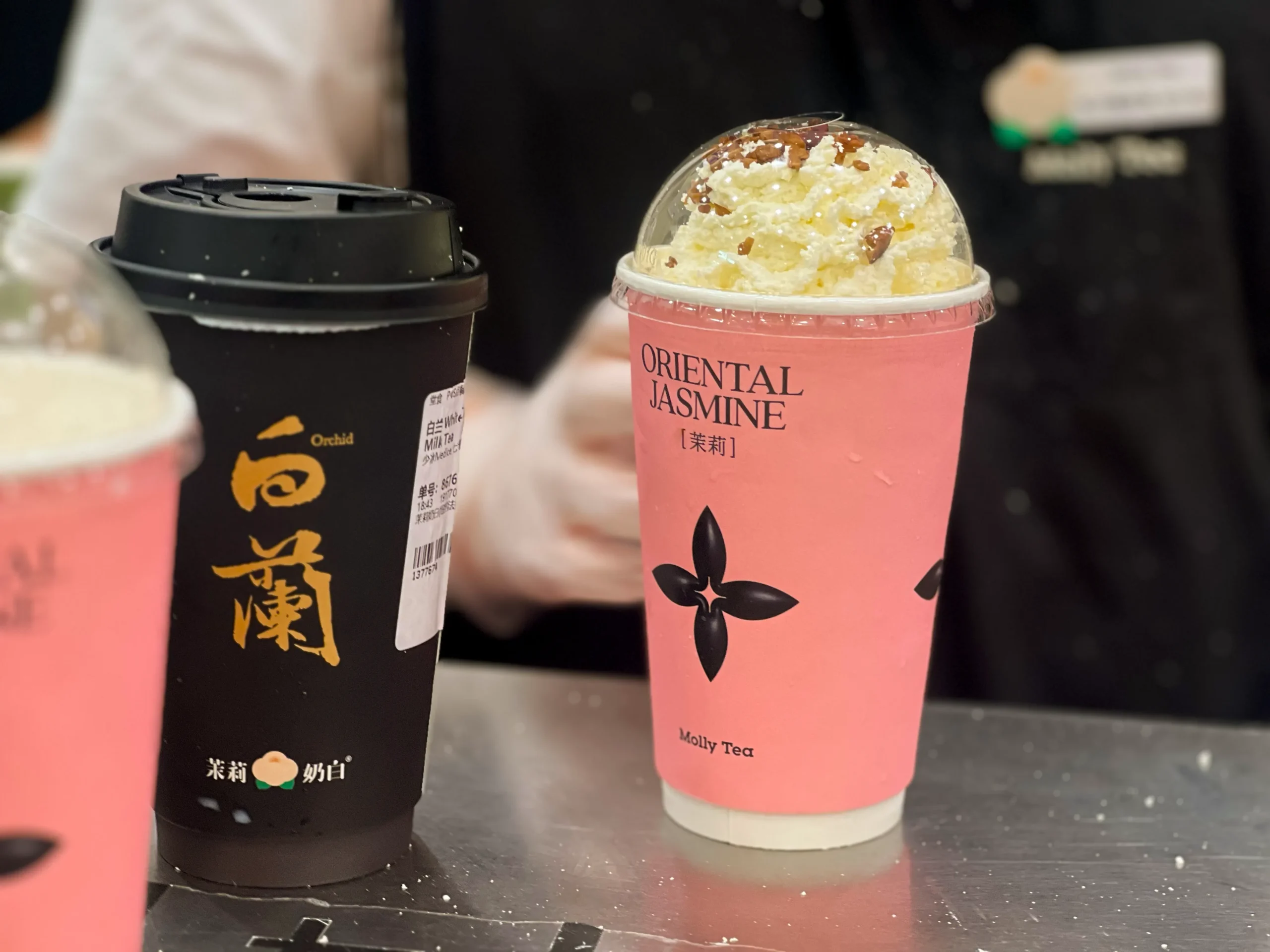 Molly Tea 茉莉奶白原品牌饮品杯,杯身带有“Oriental Jasmine”和茉莉奶白品牌标识,可与 ?Tea 临时问号杯形成对比。