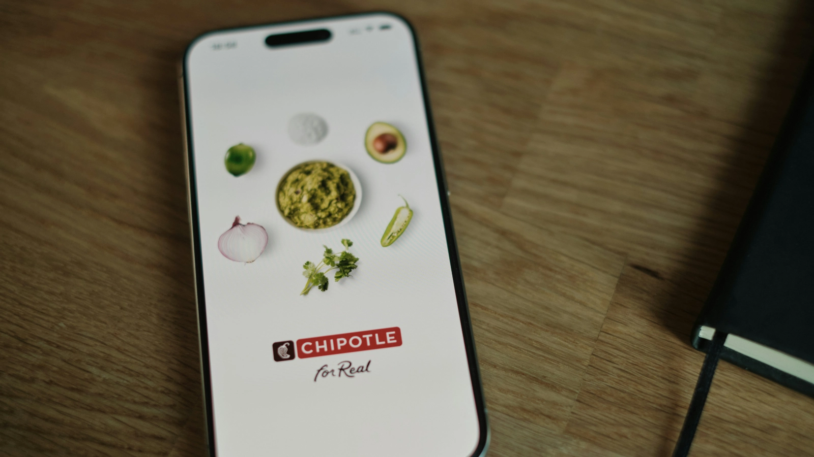 智能手机屏幕显示Chipotle应用启动页面,体现Chipotle数字化点餐与移动端用户体验